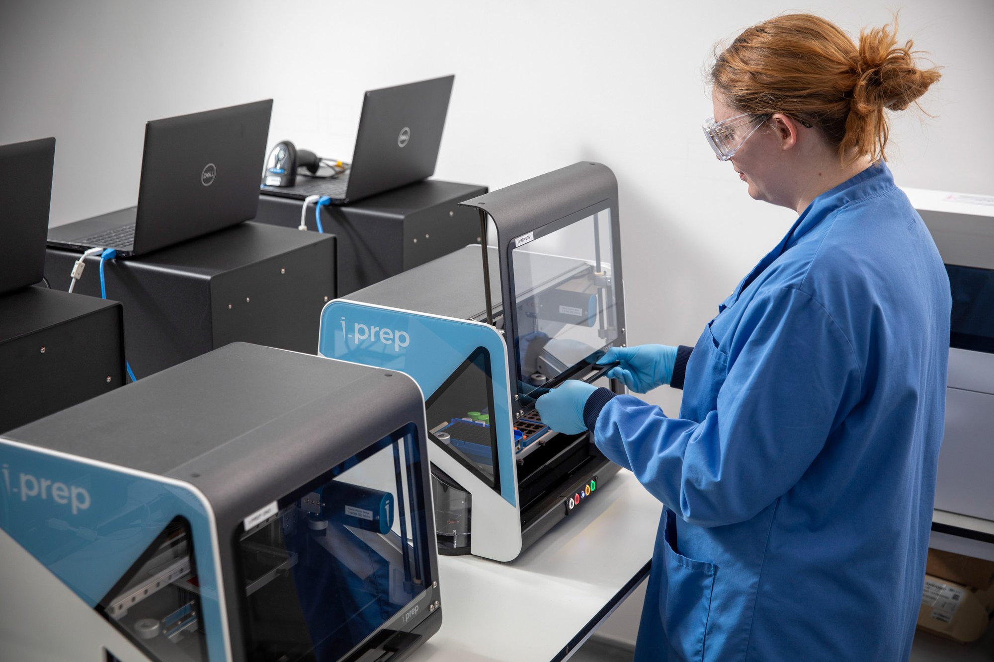 Woman placing samples into a liquid handling machine